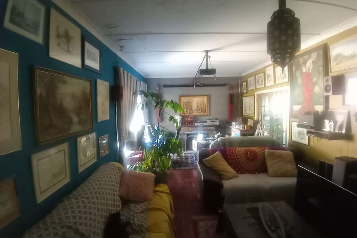 A living room featuring a fireplace and tiled flooring, currently showing signs of ceiling water damage and wear.