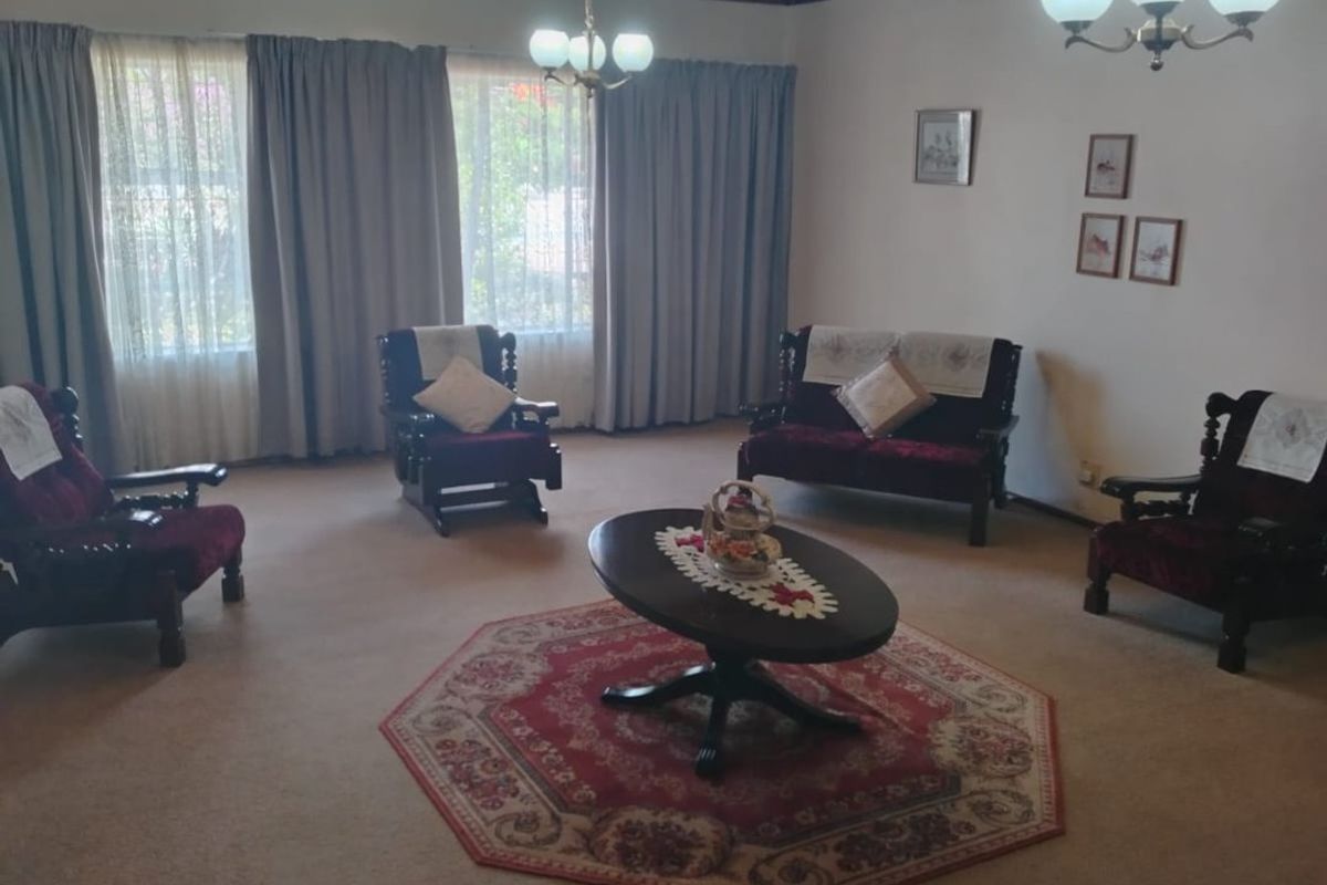 Spacious living room featuring a traditional timber tongue and groove ceiling, neutral wall finishes, and carpeted flooring.