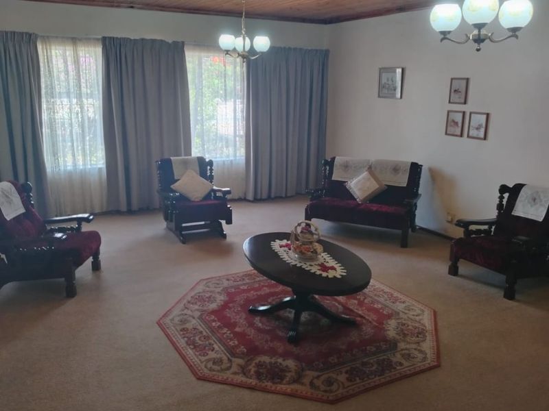 Spacious living room featuring a traditional timber tongue and groove ceiling, neutral wall finishes, and carpeted flooring.