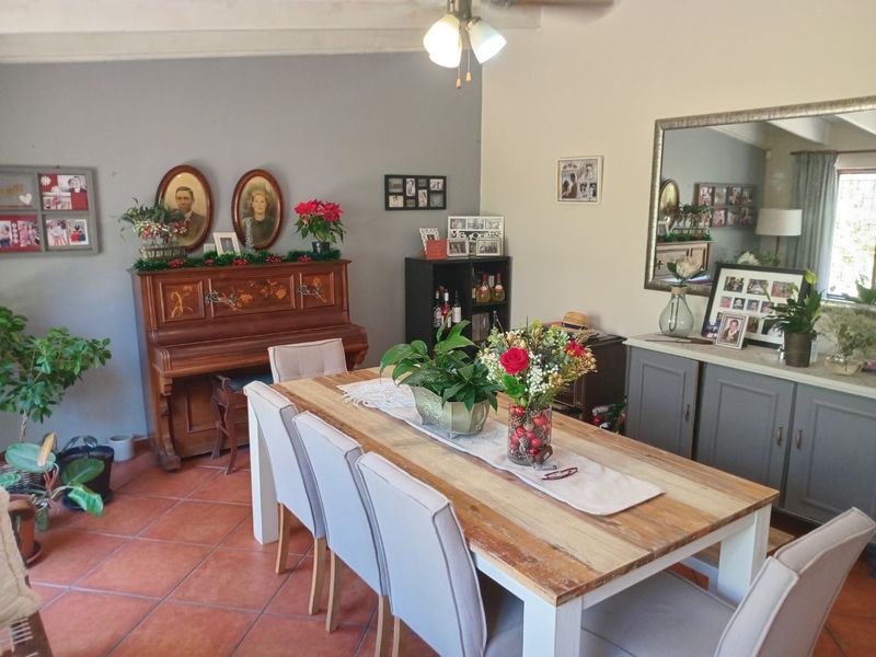 A dining room featuring terracotta floor tiles, exposed ceiling beams, and built-in cabinetry, providing a warm and functional space for family meals.