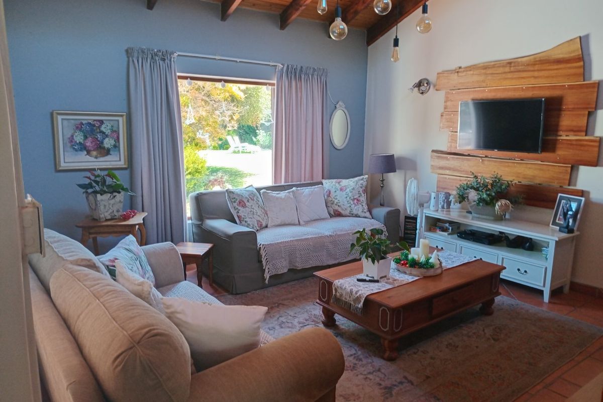 Cozy living room featuring exposed timber ceiling beams, terracotta flooring, and a rustic timber feature wall with integrated television mounting.