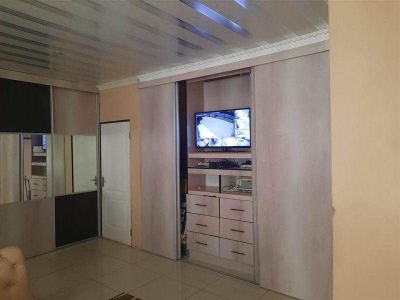 Bedroom featuring extensive built-in cabinetry with sliding doors, tiled flooring, and a coved ceiling.