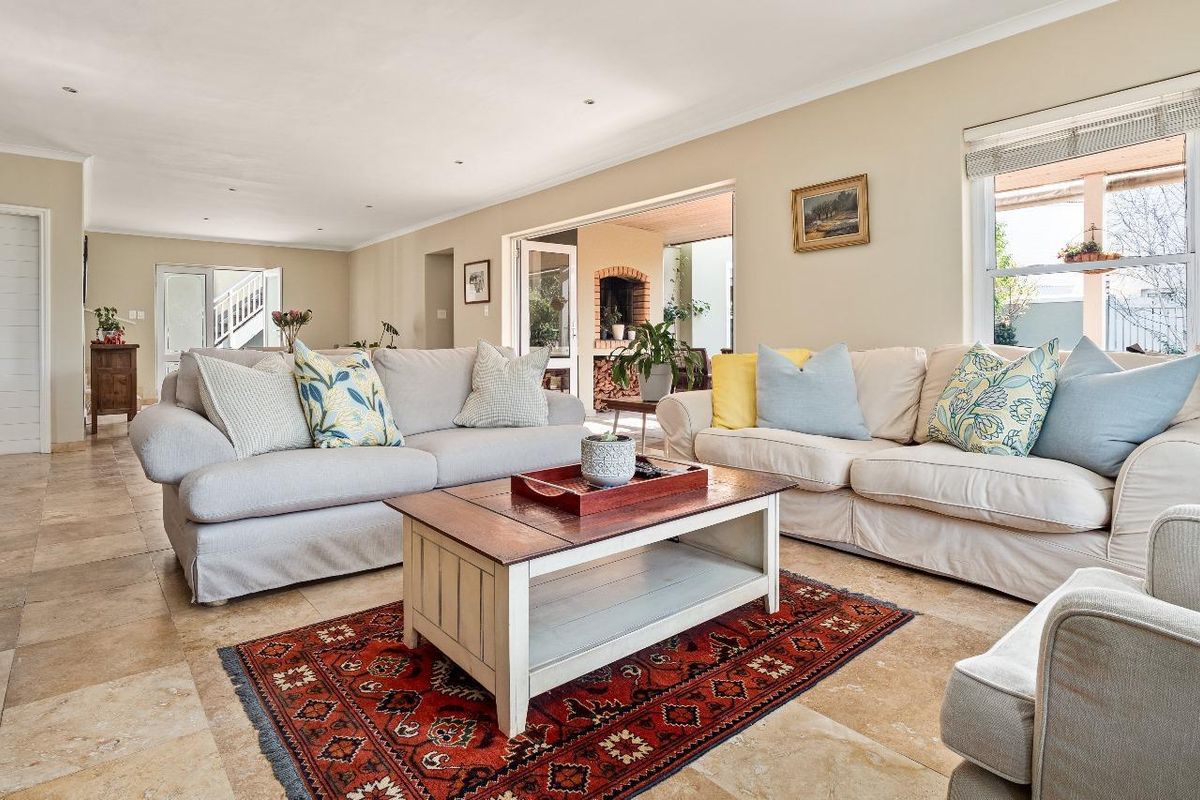 Spacious living room featuring neutral walls, tiled flooring, and large sliding doors providing seamless access to the outdoor patio area.