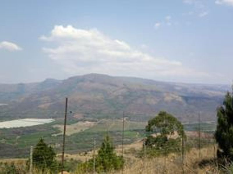 A scenic landscape view overlooking the farm property, featuring rolling hills and distant mountains.