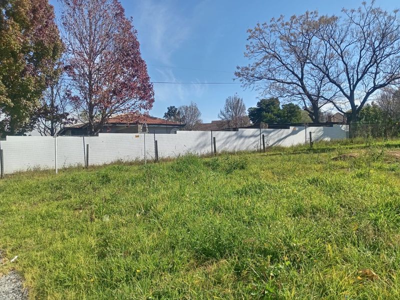 A view of an undeveloped rear yard area featuring perimeter fencing with integrated electric security wires.