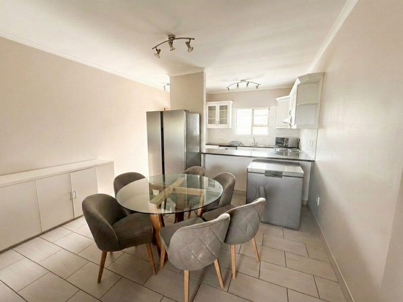 Open plan kitchen and dining area featuring tiled flooring, built-in cabinetry, and functional kitchen workspace.