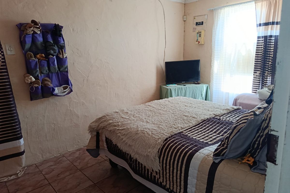 A bedroom featuring tiled flooring and visible electrical infrastructure, requiring cosmetic updates to the wall finishes and wiring management.