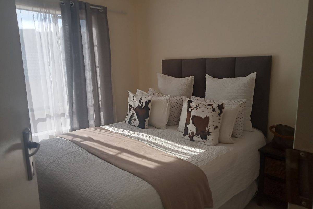A cozy bedroom featuring a neutral color palette, natural light from the window, and a clean, well-maintained interior space.