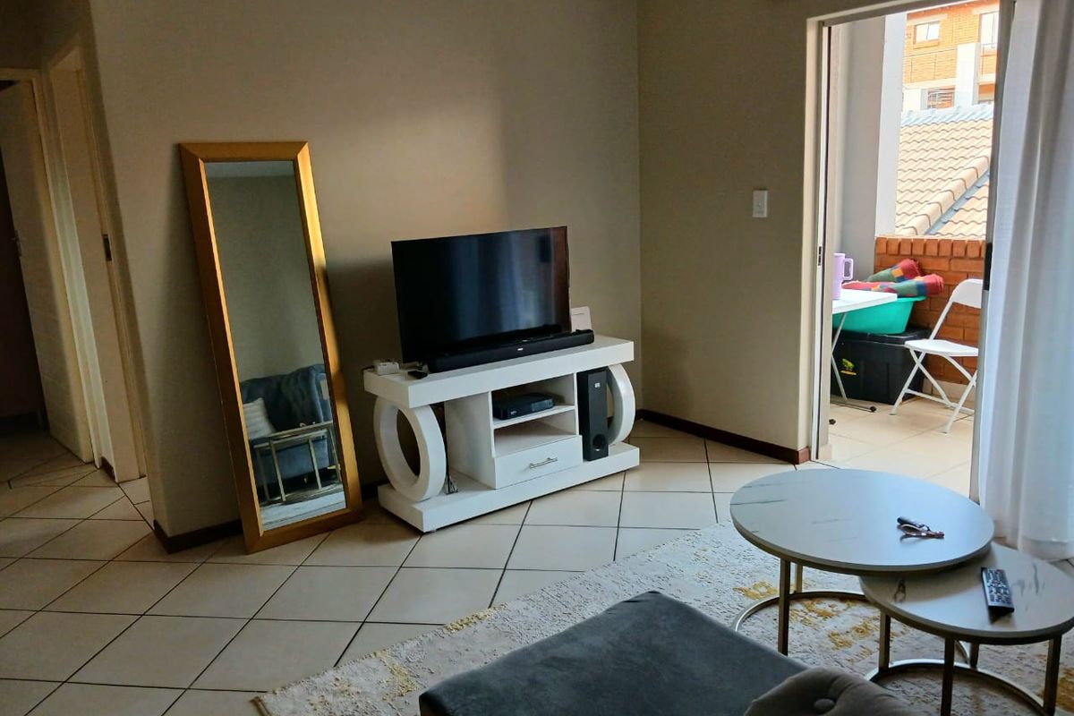 A living room featuring tiled flooring and a sliding door leading to an outdoor balcony area.
