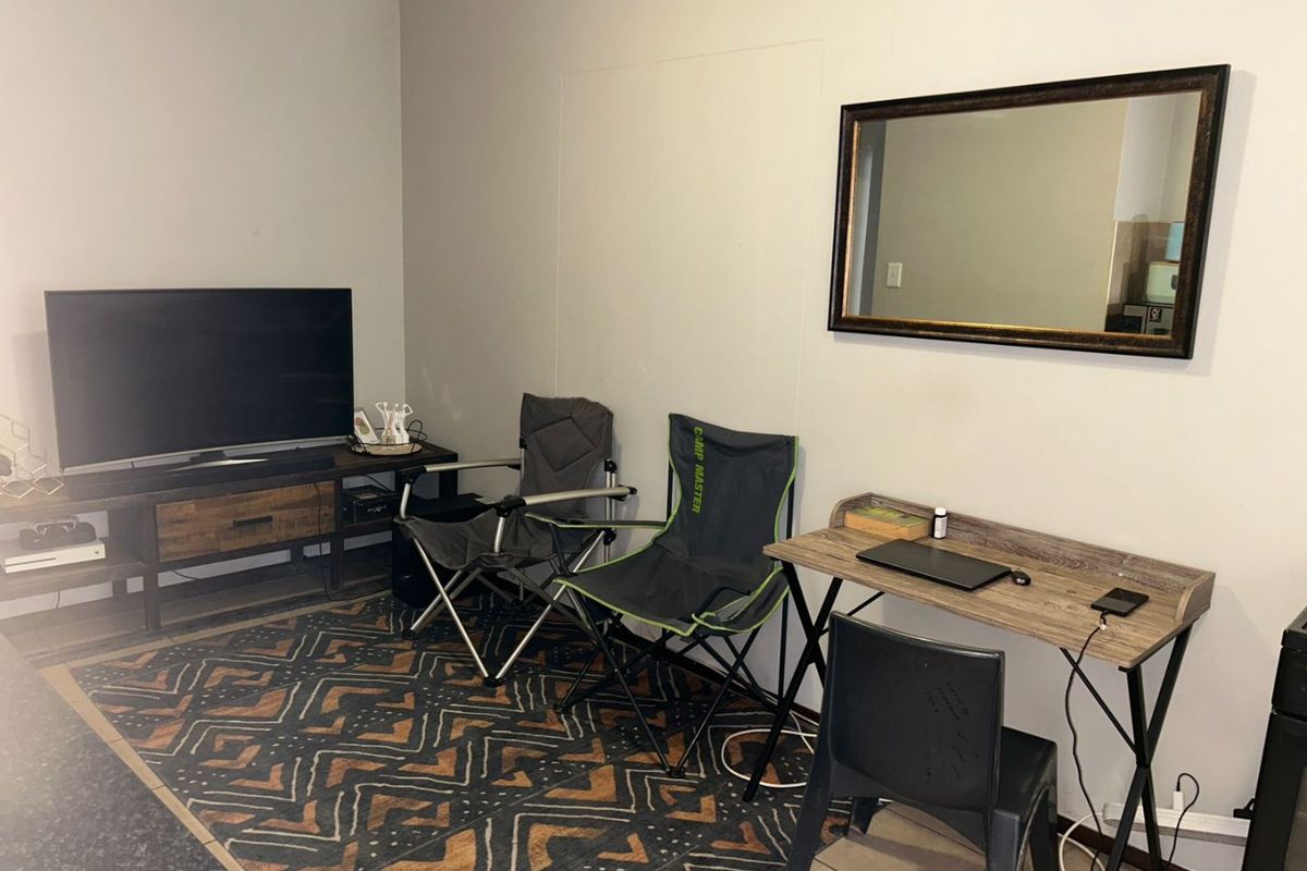 A functional living area featuring tiled flooring and neutral wall finishes, suitable for a comfortable lounge or workspace setup.