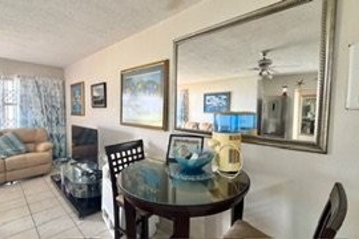 A living area featuring tiled flooring and a ceiling fan, providing a functional space for relaxation and dining.