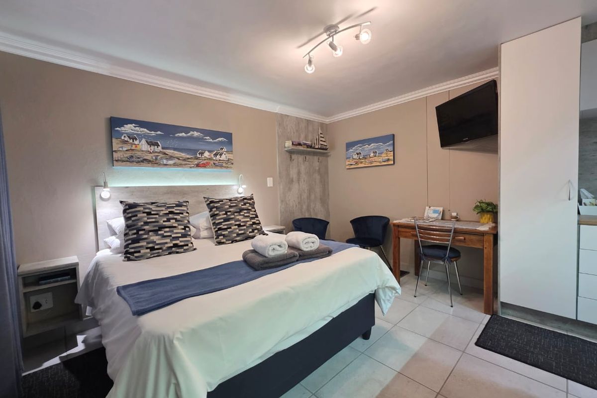 A well-maintained bedroom featuring tiled flooring, built-in wardrobe storage, and modern ceiling spotlighting, providing a comfortable and functional living space.