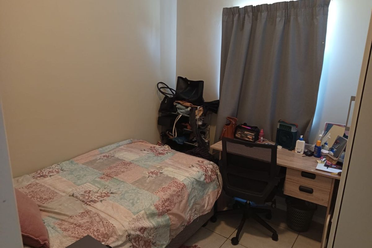 A compact bedroom featuring tiled flooring and a built-in wardrobe, providing a functional space for rest or study.