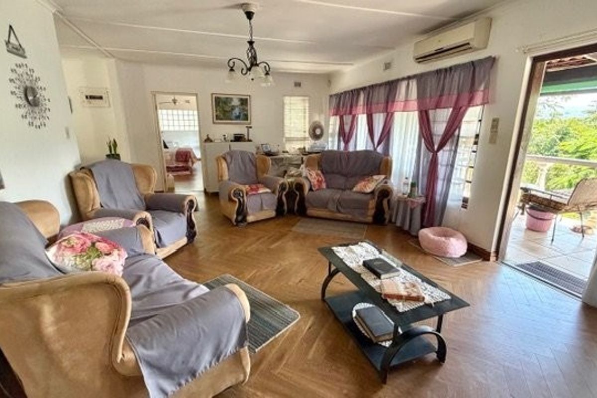 Spacious living room featuring classic parquet flooring, a wall-mounted air conditioning unit, and direct access to an outdoor patio area.