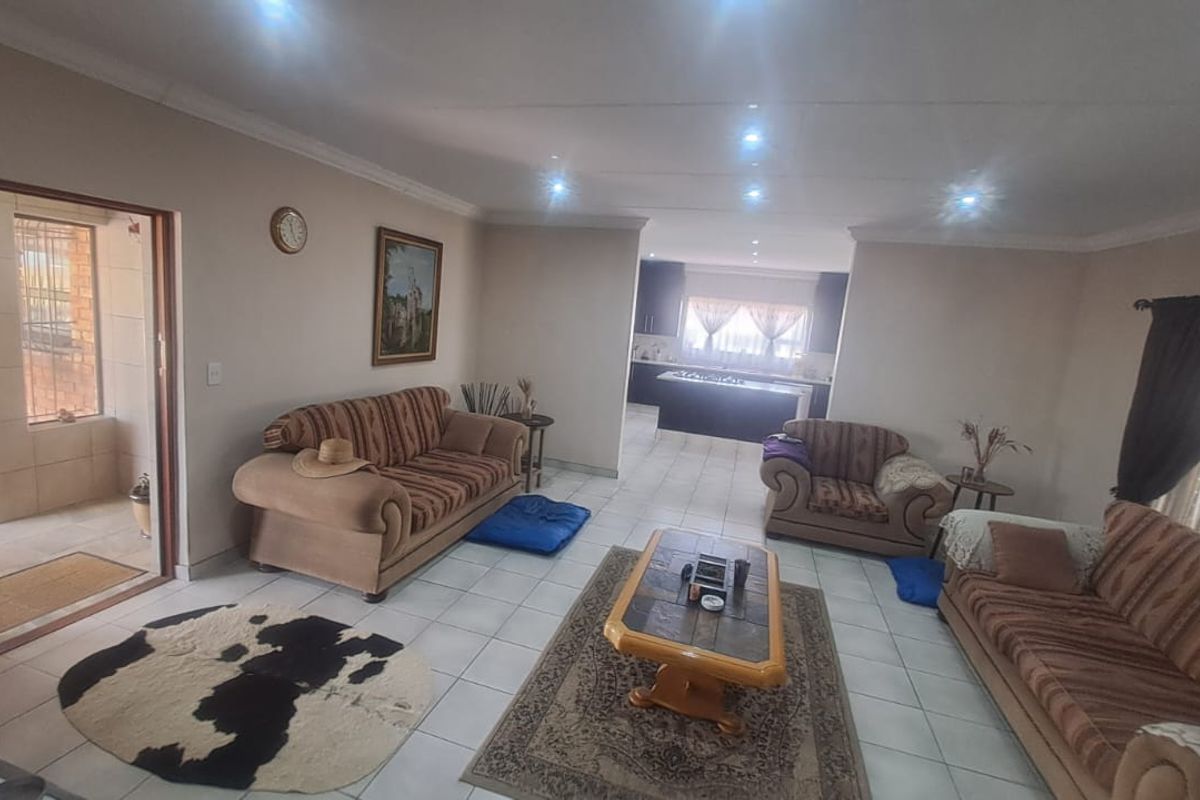 Spacious open-plan living area featuring tiled flooring, recessed lighting, and a seamless transition into the kitchen space.