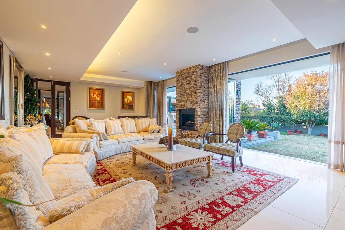 Spacious living room featuring a stone fireplace, recessed ceiling lighting, and large sliding glass doors that open to the garden.