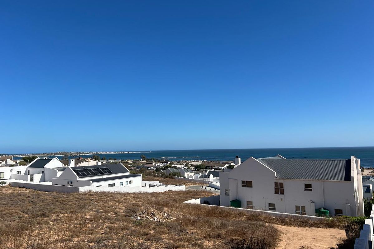 Elevated view overlooking the surrounding residential neighborhood and the coastline, showcasing the property's proximity to the ocean.