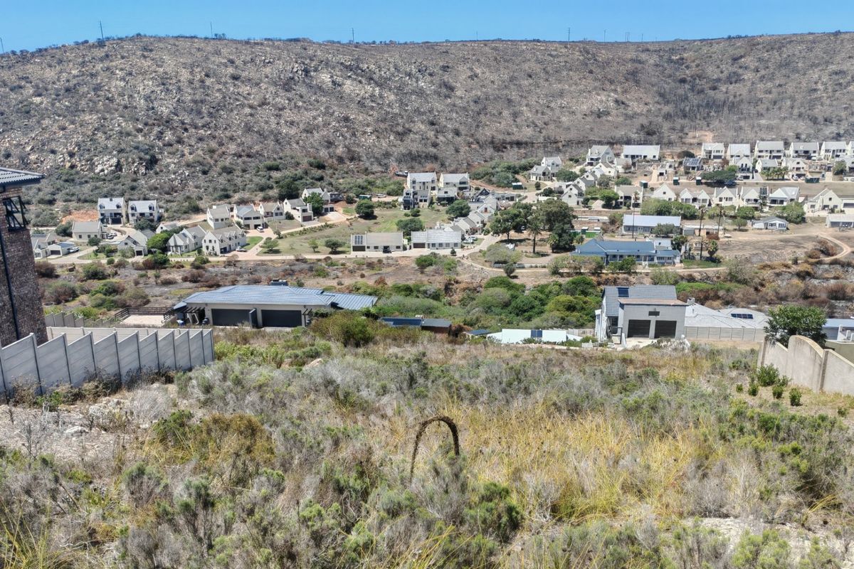 Elevated view overlooking a residential estate with surrounding natural landscape and hillside terrain.