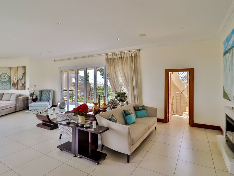 Spacious living room featuring tiled floors, recessed lighting, a built-in fireplace, and direct access to an outdoor patio through sliding glass doors.