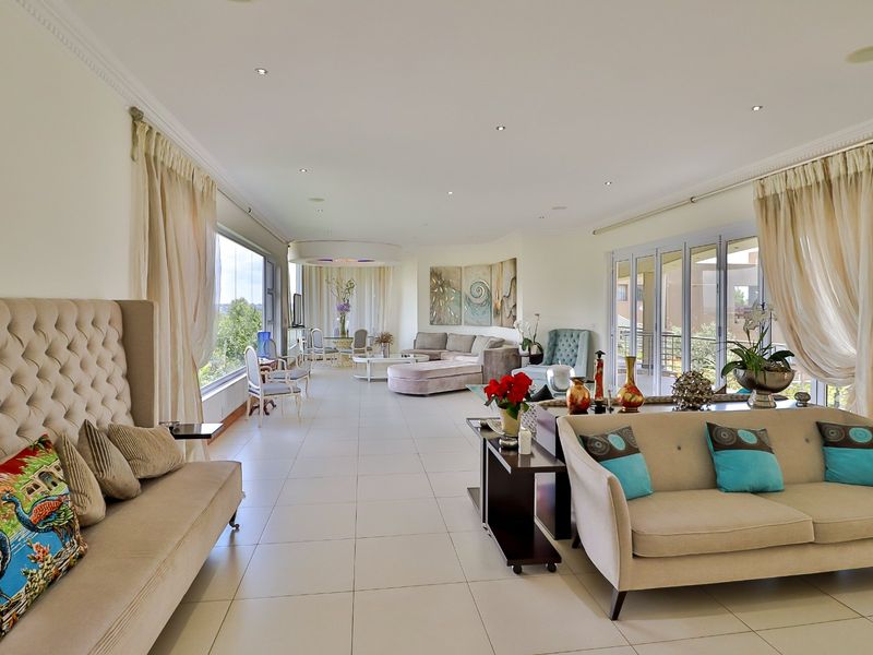 Spacious open-plan living area featuring large windows, sliding glass doors, tiled flooring, and recessed lighting, offering a bright and airy atmosphere.