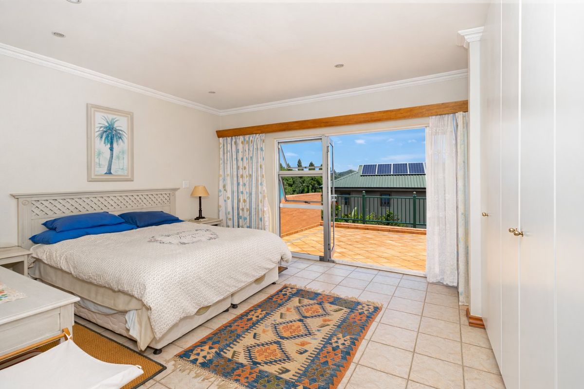 Spacious bedroom featuring tiled flooring, built-in cupboards, and direct access to a private balcony through sliding glass doors.