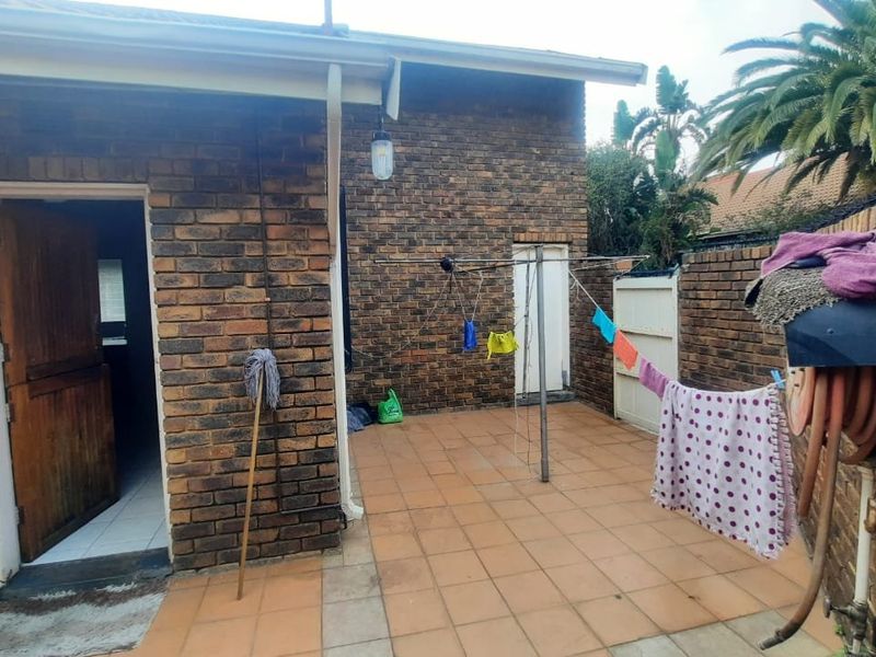 A private rear courtyard area featuring brick walls, tiled flooring, and direct access to the interior of the townhouse.