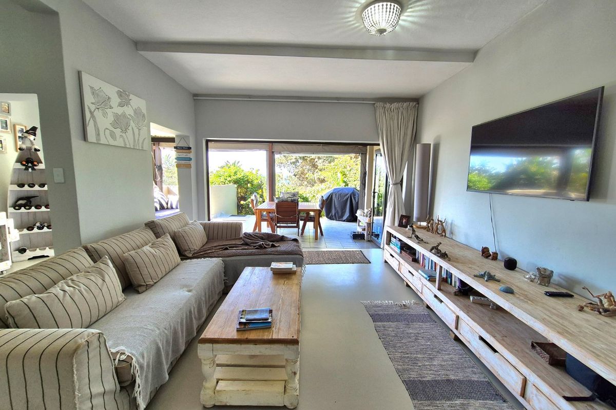 Spacious living room featuring polished concrete floors and large sliding glass doors that open onto an outdoor patio area.