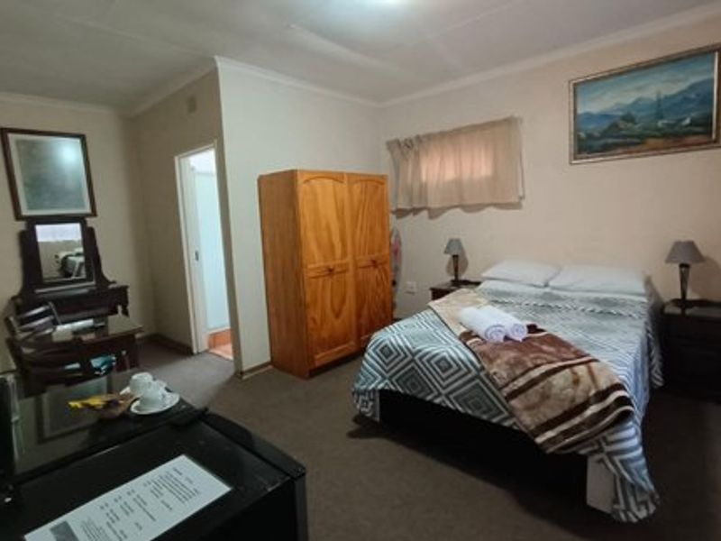 A functional bedroom featuring carpeted flooring, coved ceilings, and direct access to an en-suite bathroom.
