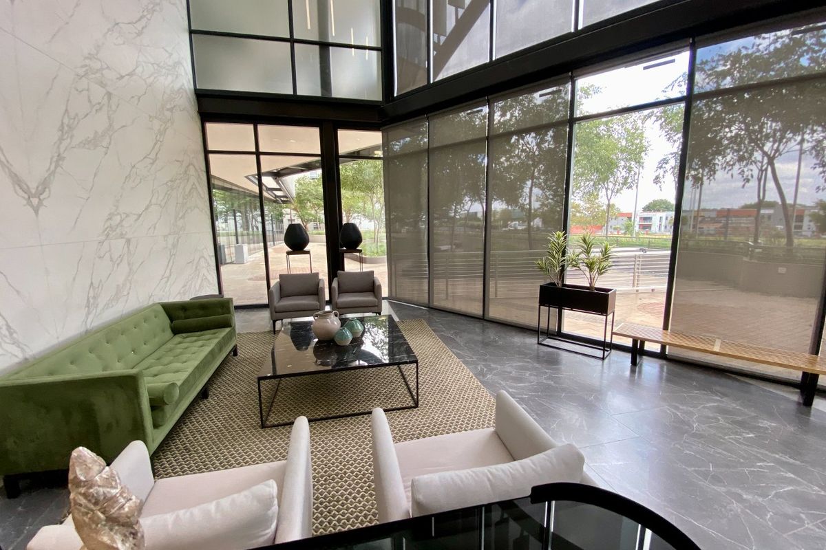 Modern double-volume commercial lounge area featuring floor-to-ceiling glass windows, marble-look wall finishes, and premium large-format floor tiles.