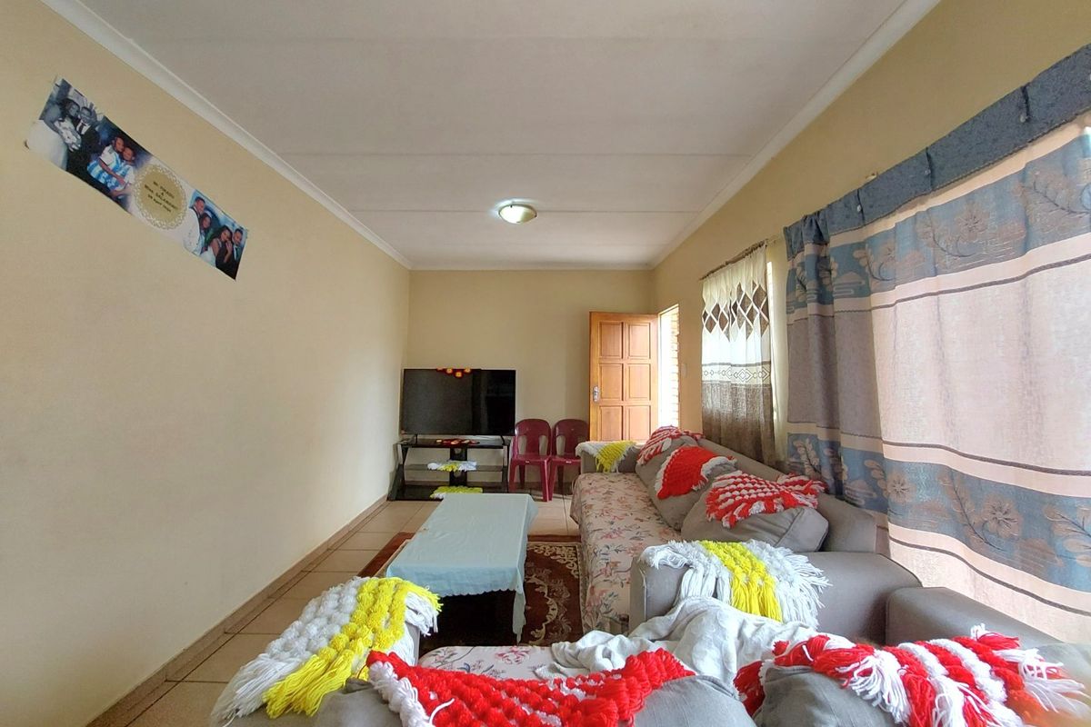 A functional living room featuring tiled flooring and coved ceilings, providing a comfortable and practical space for relaxation.