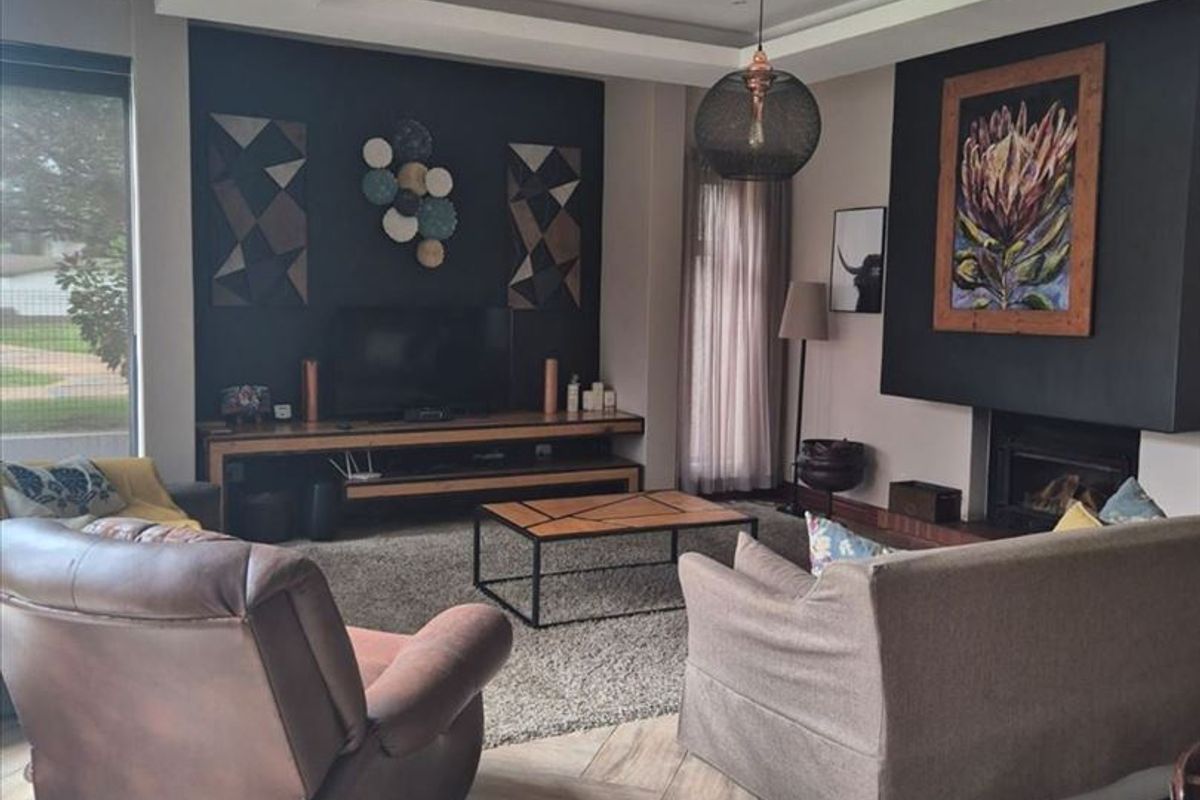 Spacious living room featuring a modern built-in fireplace, recessed ceiling with downlights, and stylish wood-look tiled flooring.