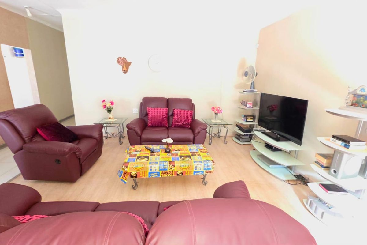 A living room featuring laminate flooring and coved ceilings, providing a functional space for relaxation.