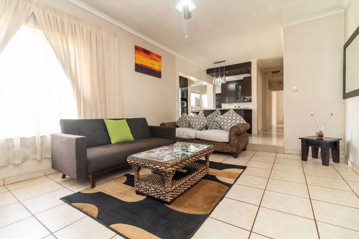 Open-plan living area featuring tiled flooring and a seamless flow into the adjacent kitchen space.
