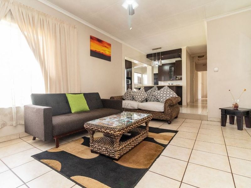 Open-plan living area featuring tiled flooring and a seamless flow into the adjacent kitchen space.