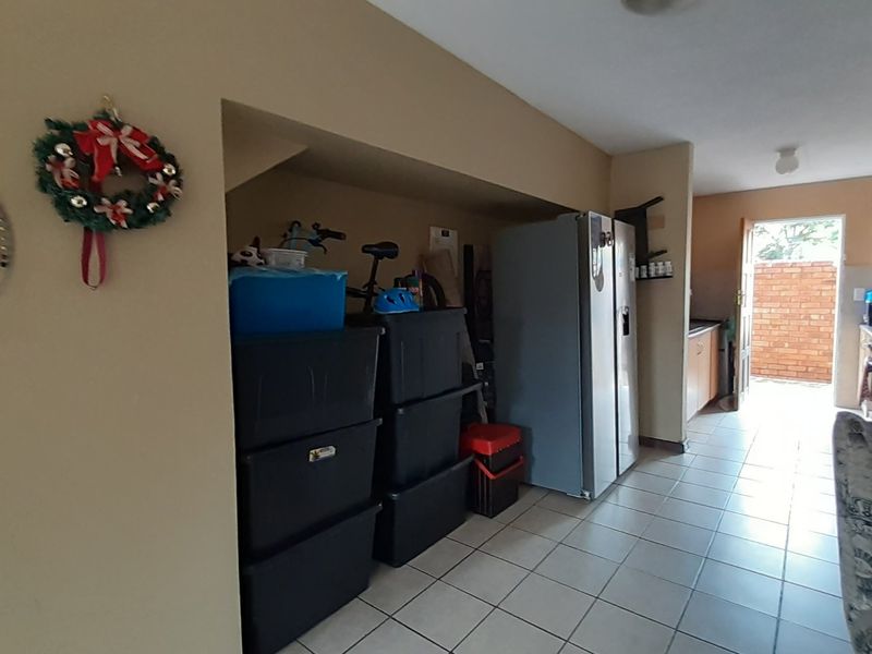 A functional kitchen area featuring tiled flooring and direct access to an outdoor space, providing a practical layout for daily use.