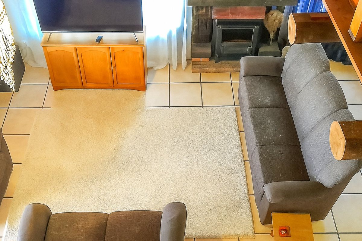 An elevated view of a living room featuring tiled flooring and a built-in fireplace, providing a cozy and functional space.