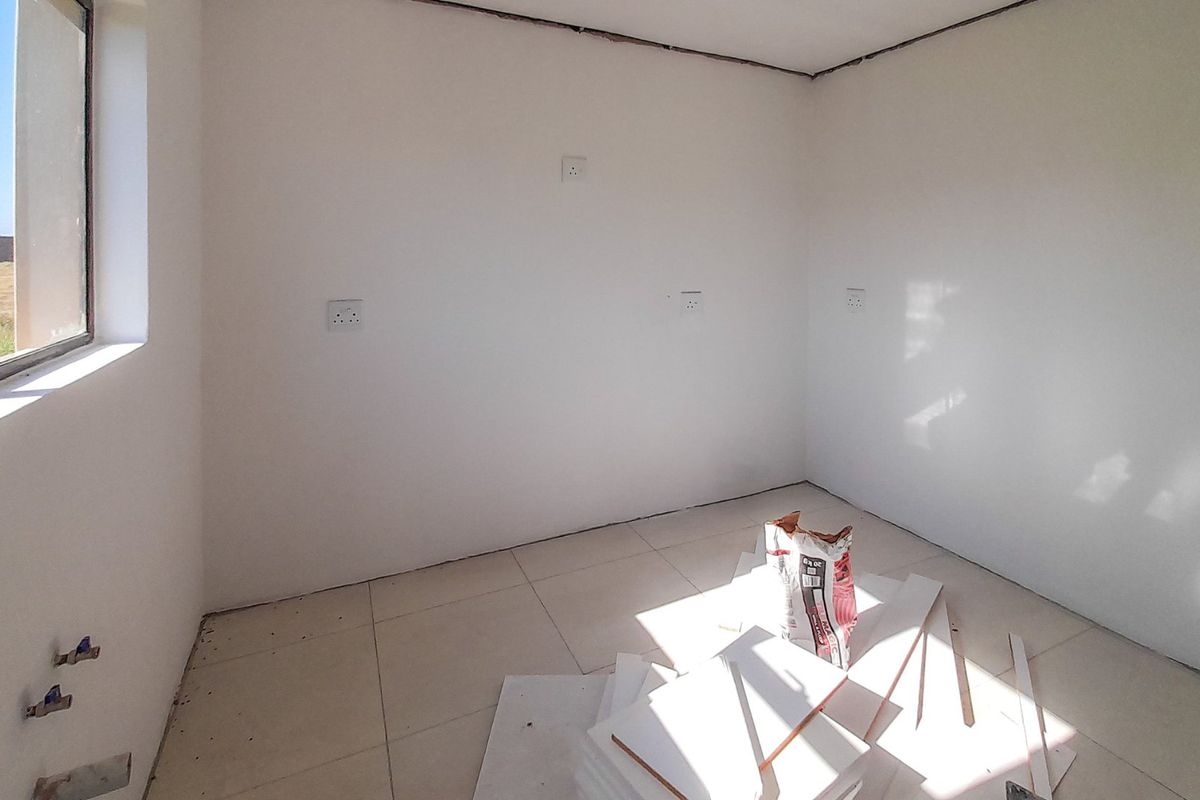 An unfinished bedroom space featuring tiled flooring, aluminium window frames, and multiple electrical power points, currently undergoing final construction or renovation work.