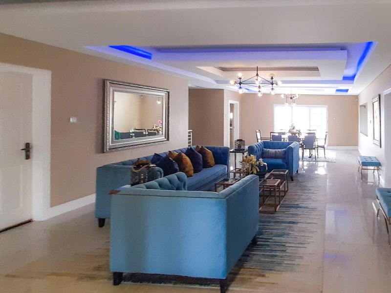Spacious open-plan living and dining area featuring modern recessed ceiling details with integrated LED lighting and polished tiled flooring throughout.