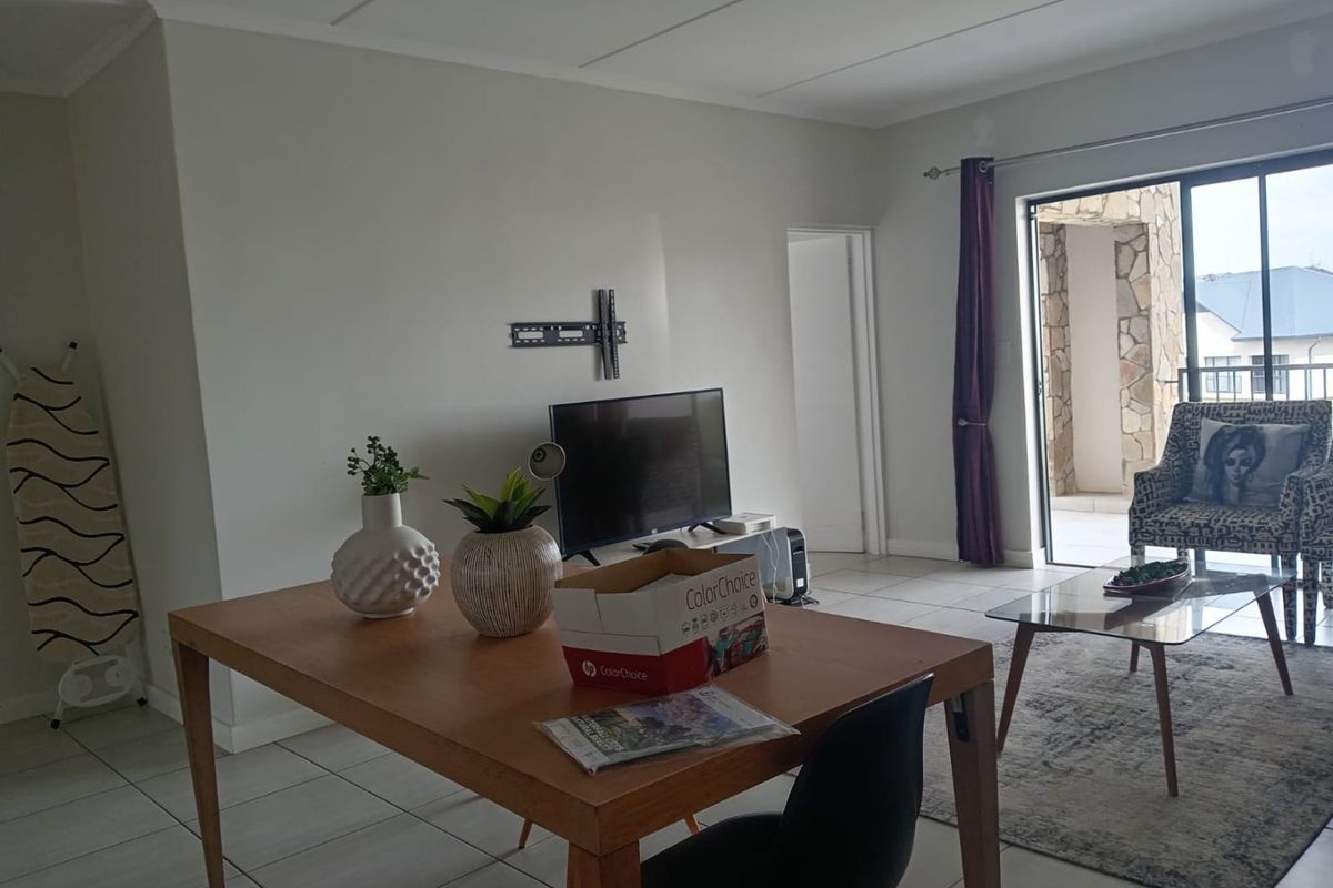 A living room area featuring tiled flooring and a sliding glass door leading to an outdoor space, with a wall-mounted TV bracket installed.