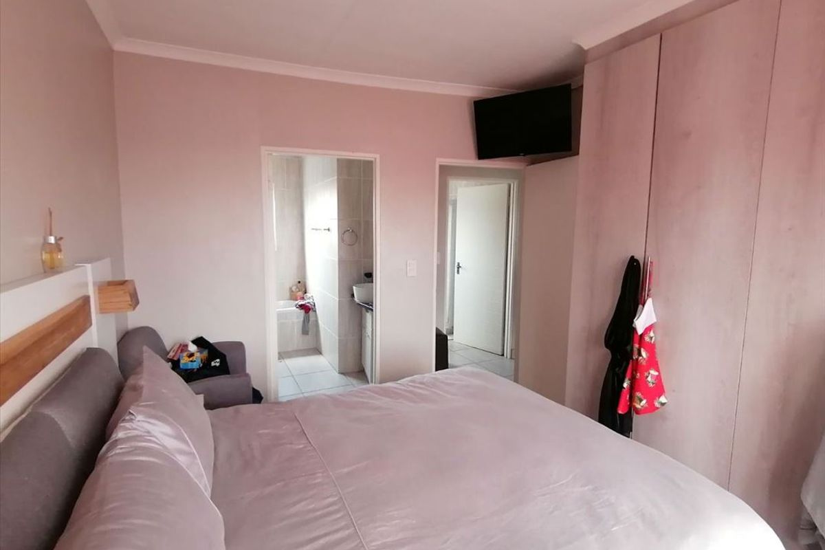 A bedroom featuring built-in cupboards, coved cornicing, and direct access to an en-suite bathroom.