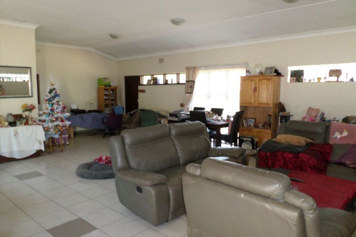 Spacious open-plan living area featuring tiled flooring and a vaulted ceiling, offering a versatile layout for dining and relaxation.