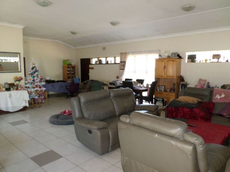 Spacious open-plan living area featuring tiled flooring and a vaulted ceiling, offering a versatile layout for dining and relaxation.
