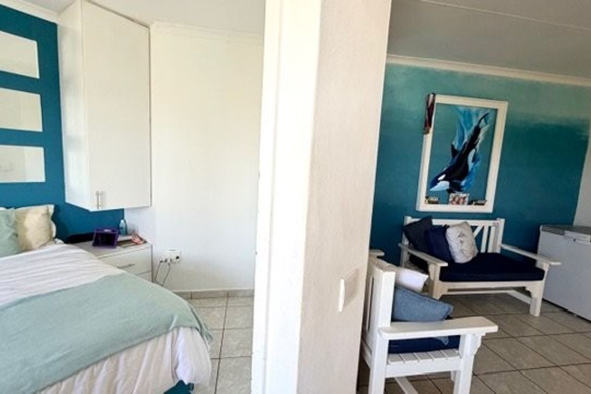 A bedroom featuring tiled flooring and built-in cabinetry, with a partitioned seating area and decorative wall finishes.