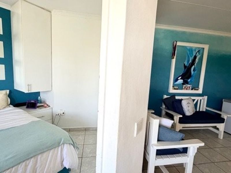 A bedroom featuring tiled flooring and built-in cabinetry, with a partitioned seating area and decorative wall finishes.