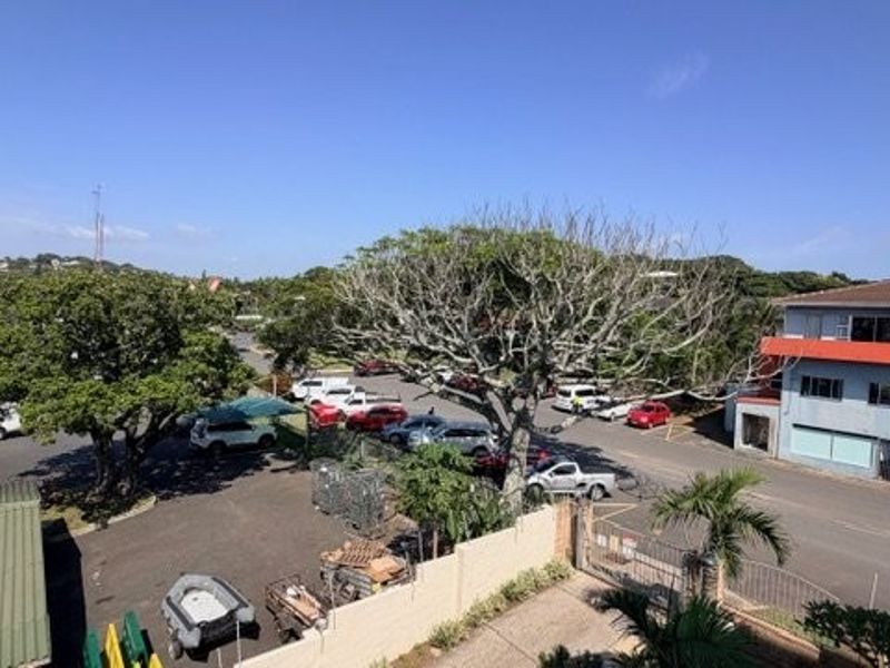 An elevated view overlooking a street, parking area, and surrounding neighborhood infrastructure.