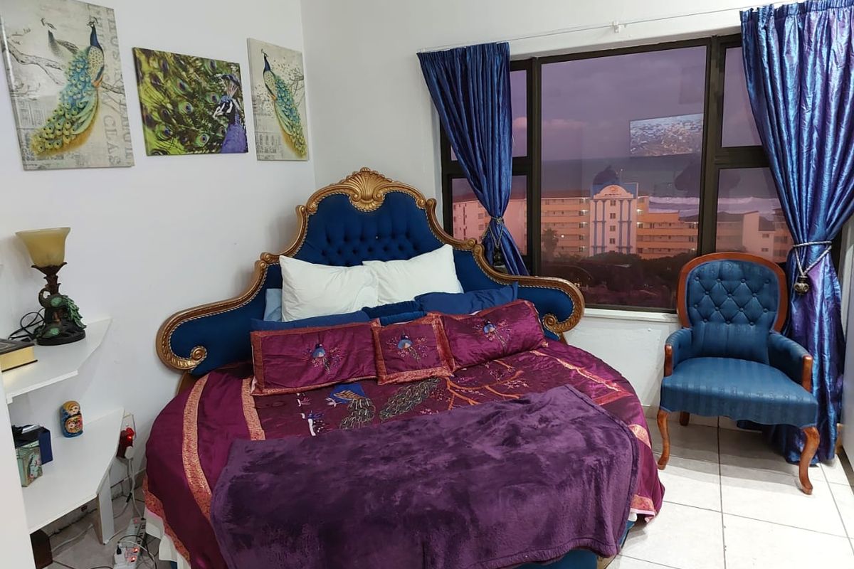 A bedroom featuring tiled flooring and a large window with views of the surrounding area.