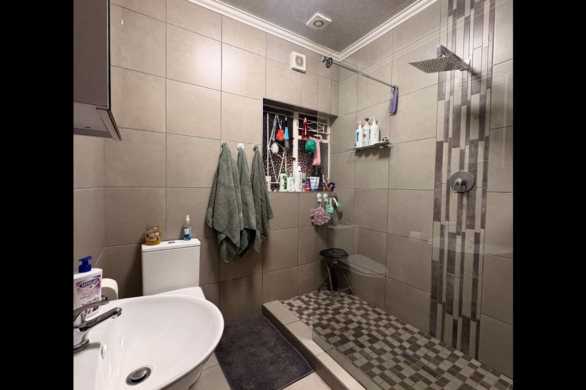 Modern bathroom featuring a walk-in shower with a rain shower head, mosaic tiling, wall-mounted toilet, and a pedestal basin.
