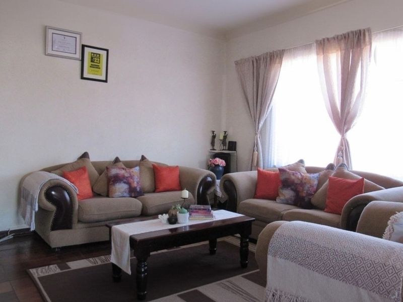 A comfortable living room featuring tiled flooring and a large window that allows for natural light.