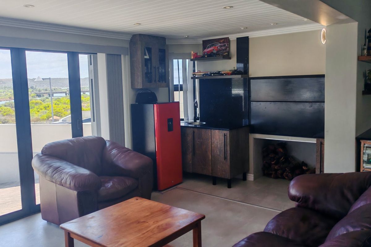 A comfortable living area featuring a built-in fireplace, kitchenette with stone countertops, and large sliding glass doors offering scenic outdoor views.