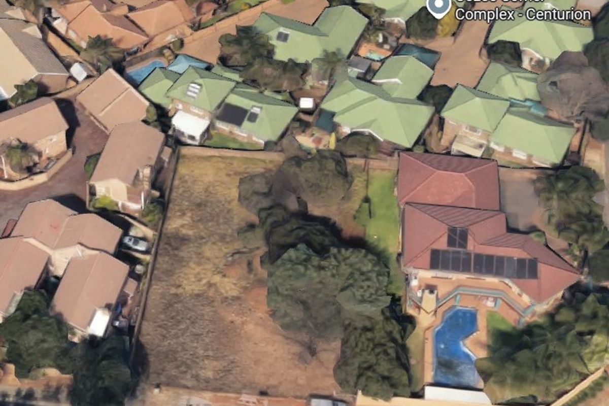 Aerial view of a vacant residential land plot situated within a developed suburban complex.